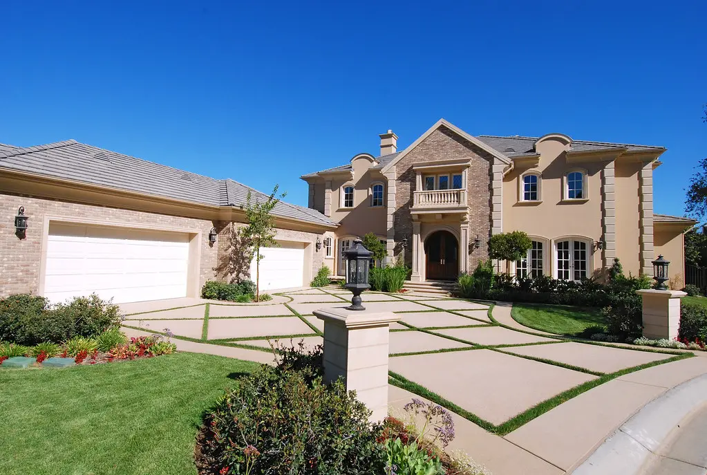 Two-story stucco home with a concrete tile roof and concrete driveway in Southern California